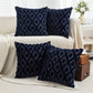 Navy blue patterned pillows on a beige sofa with a neutral background