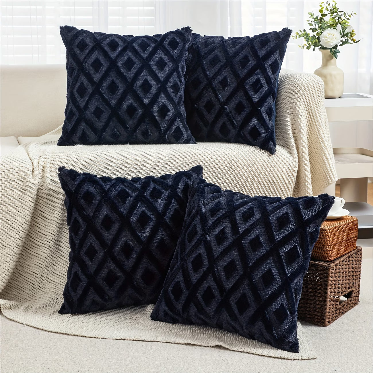 Navy blue patterned pillows on a beige sofa with a neutral background