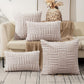 Textured throw pillows on a sofa with a decorative pineapple in the background