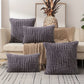 Gray textured pillows on a sofa with a pineapple decorative item in the background