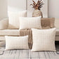 White textured pillows on a couch with a decorative pineapple in the background