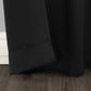 Close-up of a black curtain on a wooden floor with a neutral wall background
