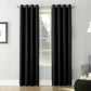 Black curtains hanging in front of a window with a neutral-colored wall and furniture in the background.