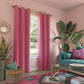 Living room with pink curtains, teal sofa, and decorative plants.