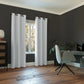 Modern room with white curtains, a chair, and a window.
