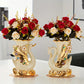 Two decorative swan vases with floral arrangements on a white surface.