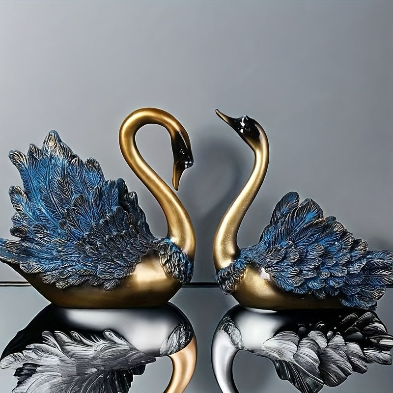 Two decorative swan figures with blue and gold feathers on a reflective surface.