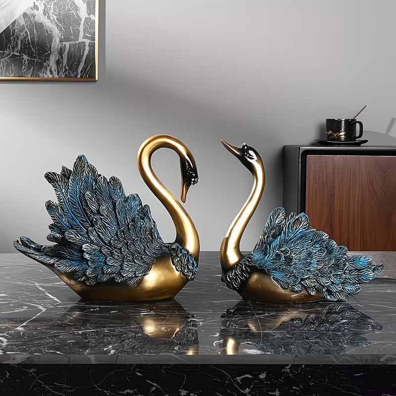 Two decorative swan statues on a marble surface with a neutral background