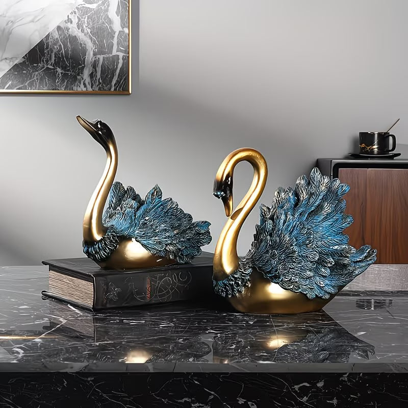 Decorative swan statues on a marble surface with a neutral background