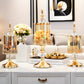 Decorative gold candle holders on a white surface with a blurred background