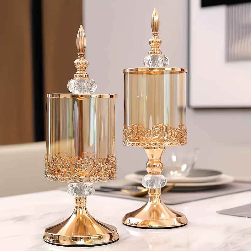 Two ornate gold candle holders on a table with a blurred background
