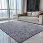 Gray rug in a modern living room with a beige sofa and large windows.