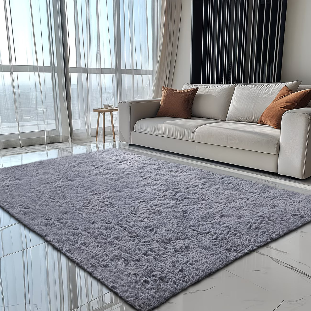 Gray rug in a modern living room with a beige sofa and large windows.