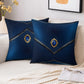Two decorative blue pillows with gemstones on a couch.