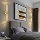 Modern bedroom with gray bedding, abstract art, and wall sconces.