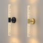 Two modern wall sconces, one black and one gold, on a neutral wall.