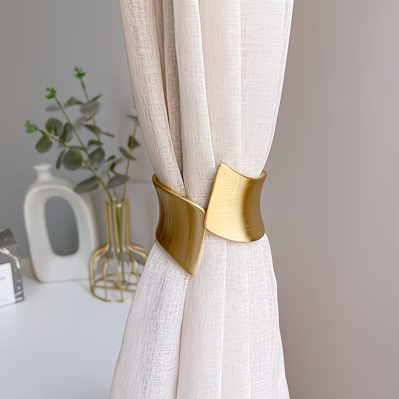 White curtain with gold tieback against a neutral background