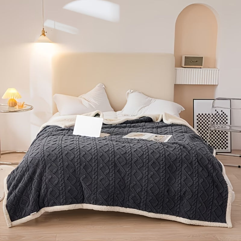 Gray textured blanket on a bed in a bedroom setting with a lamp and nightstand.