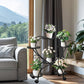 Living room with a gray sofa, decorative plant stand, and large window showing a mountain view.