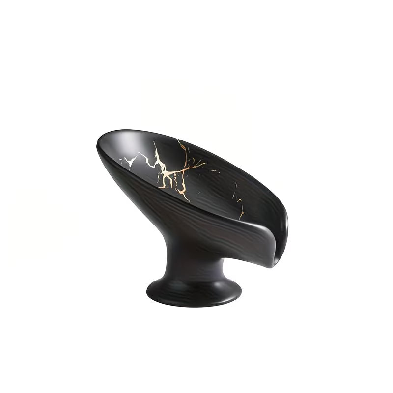 Black decorative object with gold accents on a white background