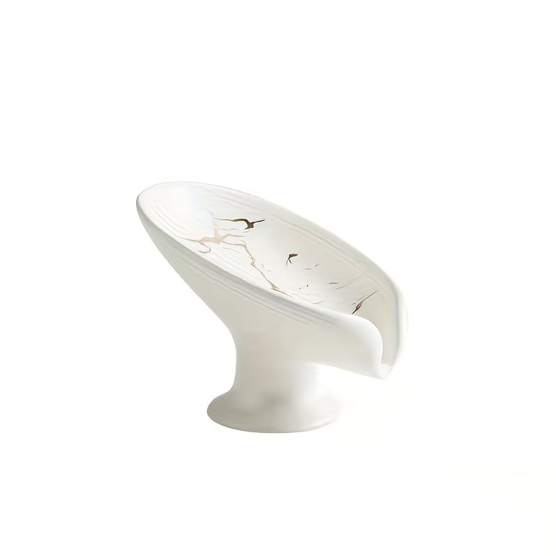 White ceramic bowl with gold leaf design on a white background