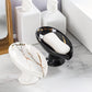 Two marble-patterned soap dishes with soap on a bathroom counter.