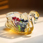 Gold swan-shaped dish with fruits on a beige surface