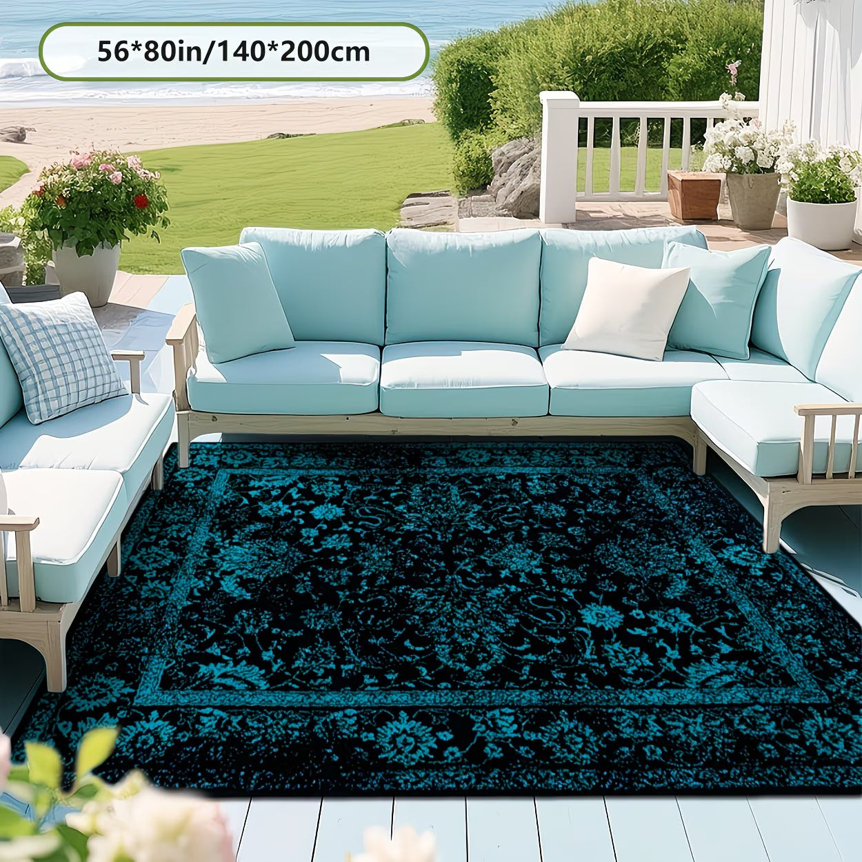 Outdoor seating area with a blue and black patterned rug, light blue cushions, and a scenic background.
