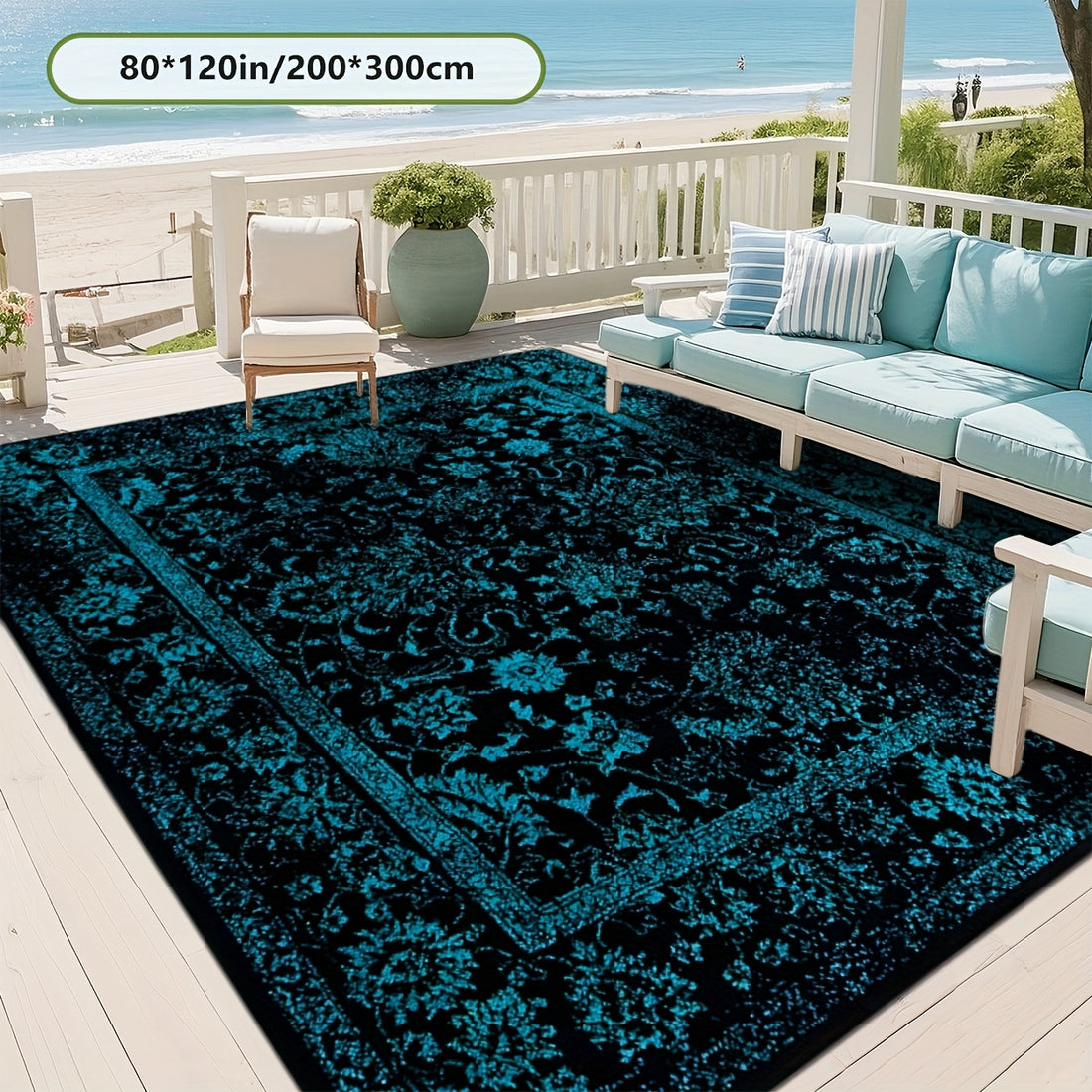 Teal and black patterned rug on a patio with outdoor furniture and ocean view.