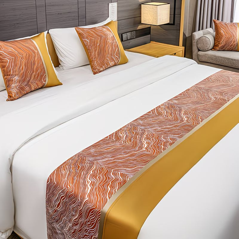 Bed with decorative pillows and a patterned bed runner in a bedroom setting.