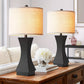 Two table lamps with beige shades on a wooden surface in a living room setting.