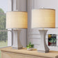 Two table lamps with beige shades on a wooden surface, with a smartphone displaying a charging icon in the background.