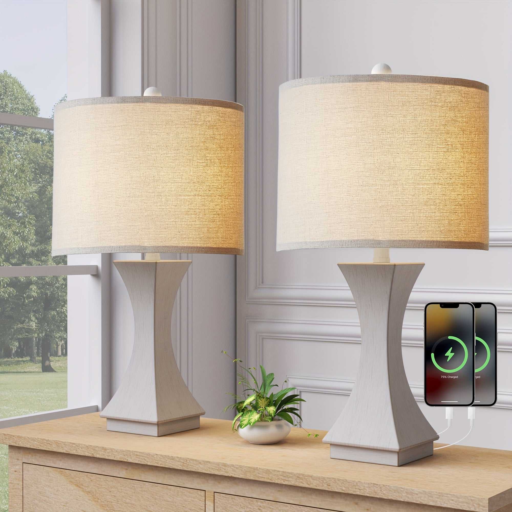 Two table lamps with beige shades on a wooden surface, with a smartphone displaying a charging icon in the background.
