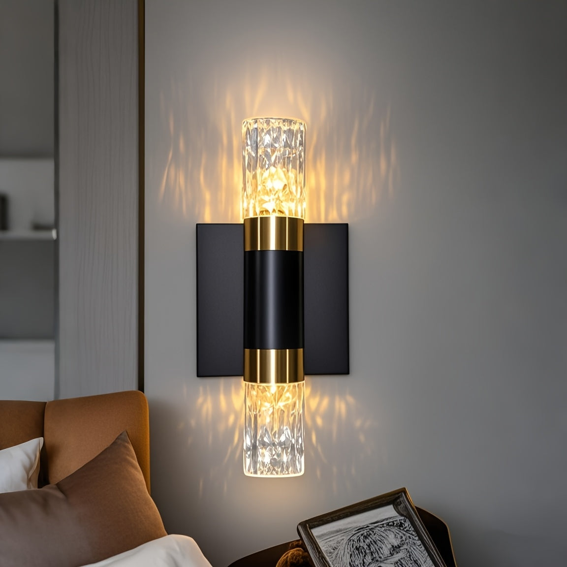 Modern wall sconce with glass shade and gold accents on a gray wall.