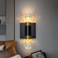 Modern wall sconce with glass shade and gold accents on a gray wall.