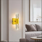 Modern wall sconce with yellow fixture and clear glass shade in a living room setting.