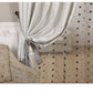 Decorative curtain with tassel and patterned fabric on a neutral background
