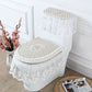 White lace-covered toilet set on a white toilet with decorative flowers and magazine in the background.