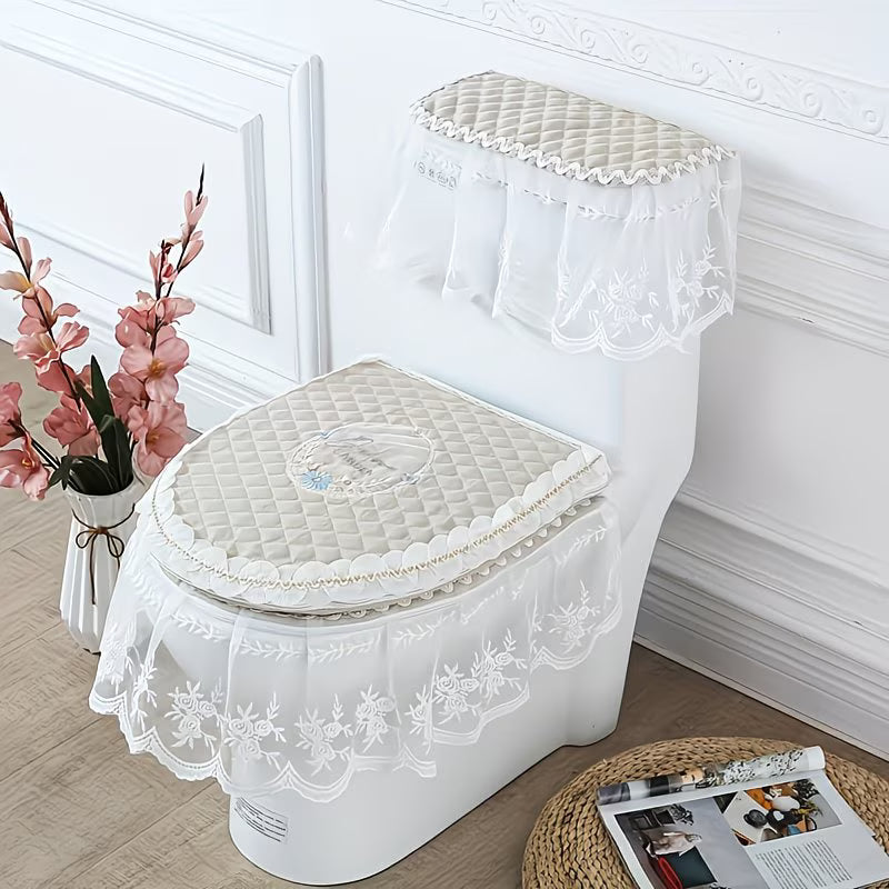 White lace-covered toilet set on a white toilet with decorative flowers and magazine in the background.