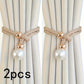 Two decorative curtain ties with pearl and gold accents on beige curtains.