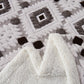 Close-up of textured white fabric with a patterned background
