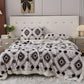 Bedroom with a bed featuring a patterned comforter and pillows.