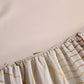 Close-up of a curtain with gold wave patterns on a plain background