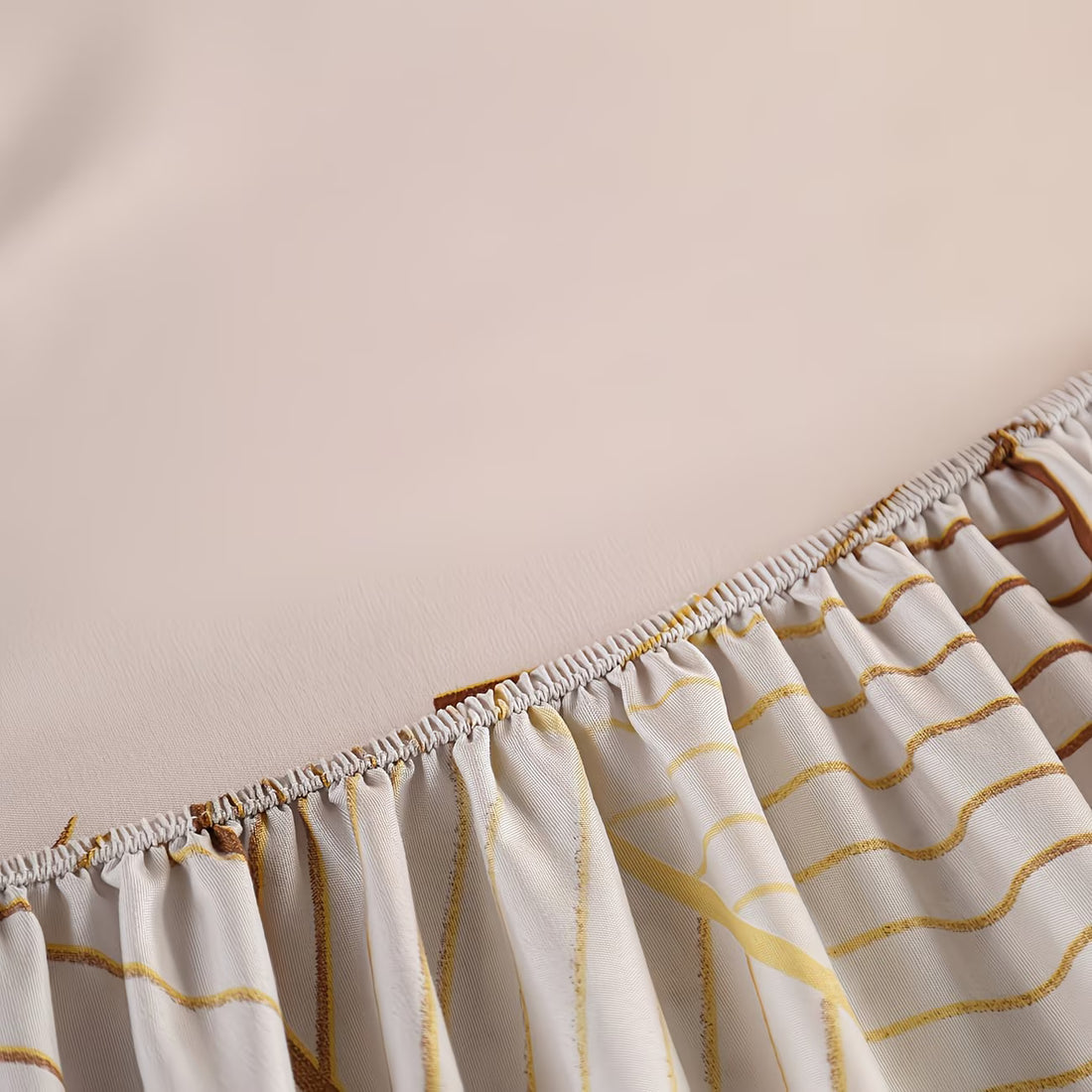 Close-up of a curtain with gold wave patterns on a plain background
