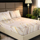Bed with leaf-patterned bedding in a bedroom setting