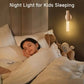 Child in bed with a night light on the wall above, promoting a cozy bedtime atmosphere.