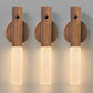 Three wooden wall sconces with light fixtures on a neutral background