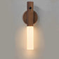 Wooden wall sconce with a light fixture on a plain background