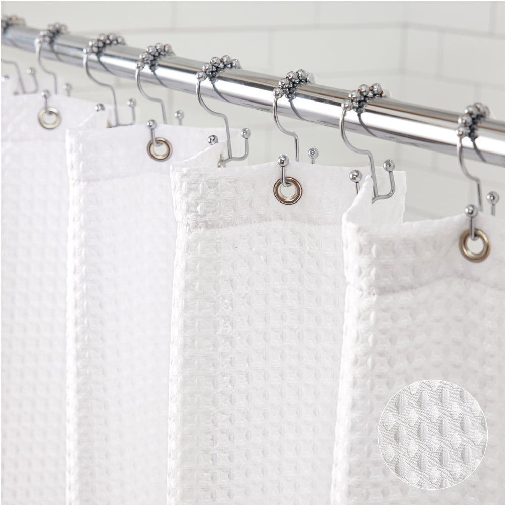 Shower curtain with hooks attached to a rod against a tiled wall.
