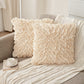 Two textured pillows on a sofa with a cup and book in the foreground.